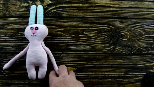 Toy-plush-hare-on-a-wooden-background