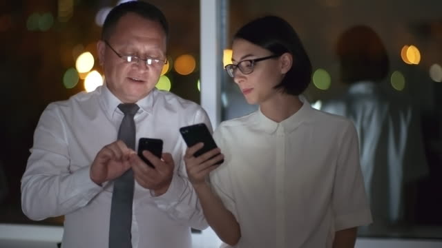 Coworkers-Browsing-the-Net-on-Smartphones-in-Dark-Office