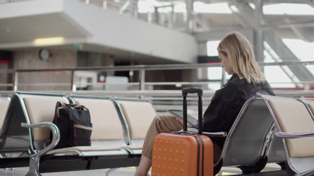 Mujer-con-un-dispositivo-digital-en-el-aeropuerto