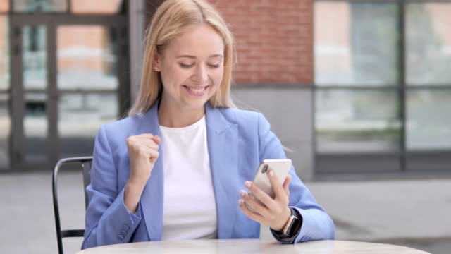 Young-Businesswoman-Excited-for-Success-on-Smartphone