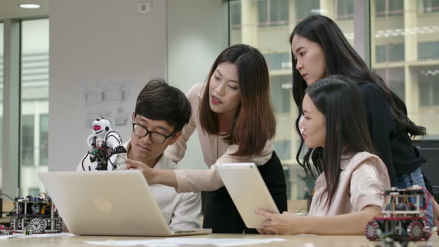 Junge-asiatische-Kreative-Treffen,-Programmierung-für-kollaborative-universelle-Robotik-am-Laptop-in-der-Werkstatt.-Menschen-mit-Technologie--oder-Innovationskonzept.