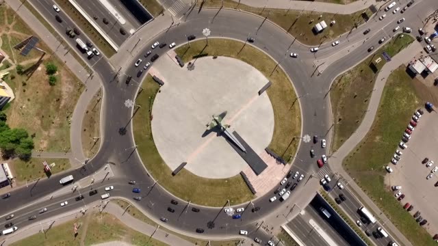cars-are-moving-on-round-intersection-in-city-in-summer-day,-aerial-shot