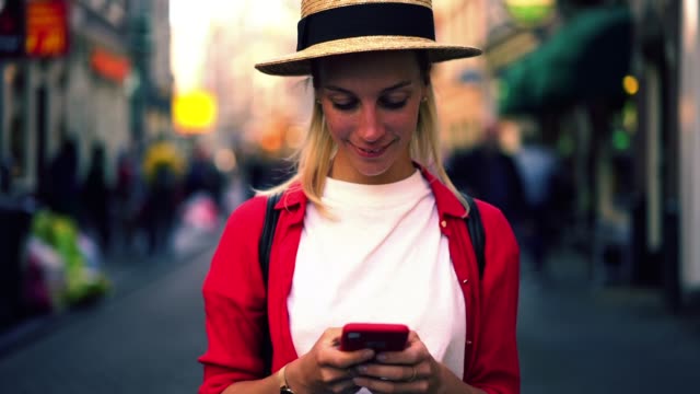 low-motion-effect-if-Caucasian-authentic-female-holding-smartphone-in-hands-and-sincerely-smiling-after-read-text-message-on-mobile-phone
