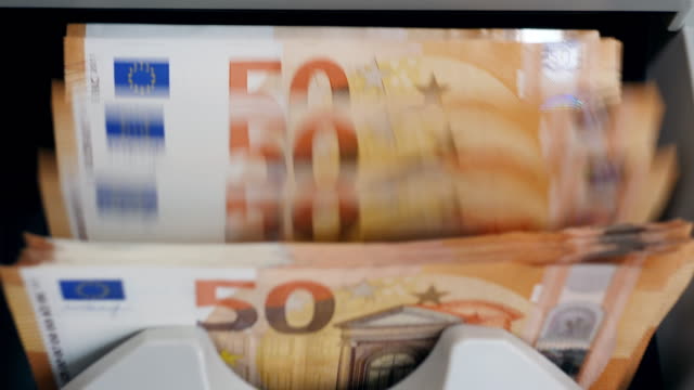 Orange-euro-bills-moving-in-a-counter-while-checked.