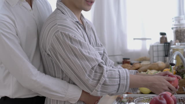 Asian-couple-gay-housekeeping-in-morning-at-home.-Gay-boy-happy-emotion-and-hug-love-anniversary-together.-Concept-of-lifestyle,-family,-gay-and-bisexual.