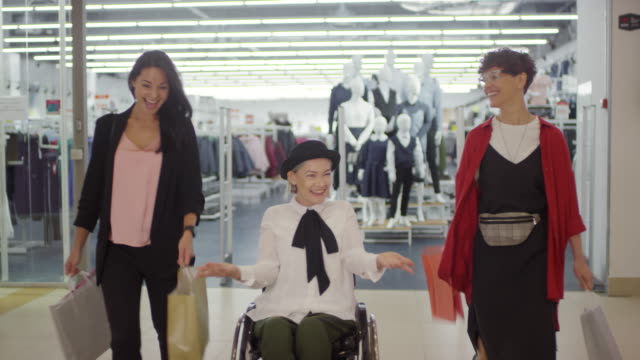 Aufgeregte-behinderte-Frau-und-ihre-weiblichen-Freunde-in-Shopping-Mall