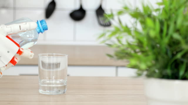 Roboter-Prothesenhand-gießt-Wasser-in-Glas-aus-der-Flasche-in-der-Küche