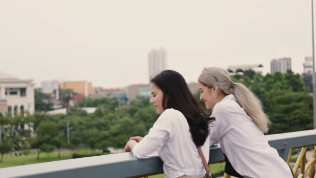 Asian-lesbian-couples-enjoying-traveling-and-talk-while-standing-on-the-bridge.-LGBT-concept.