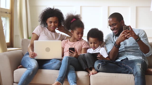 African-couple-and-little-kids-addicted-to-modern-gadgets