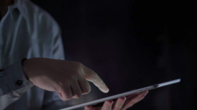 4K-Video-close-up-man-hand-using-tablet-with-black-background.