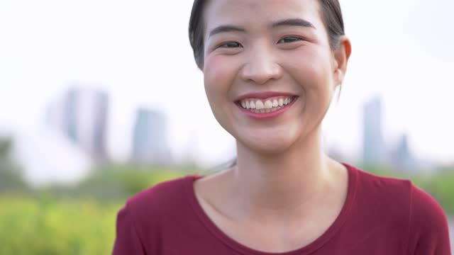 Close-up-face-of-asian-woman-using-smart-phone.-Happy-female-face-with-white-teeth-pretty-face-posing-for-close-up-portrait-outdoor.