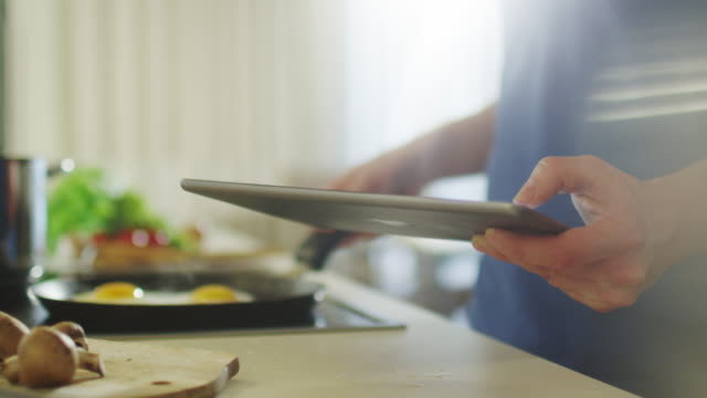 El-hombre-es-utilizar-Tablet-PC-mientras-prepara-alimentos