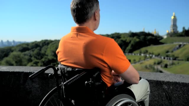 Konzentrierte-wheelchaired-Mann-genießen-den-Blick-über-die-Kirche