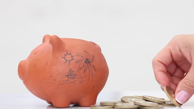 Woman-saving-money-into-a-traditional-clay-piggy-bank-for-holidays