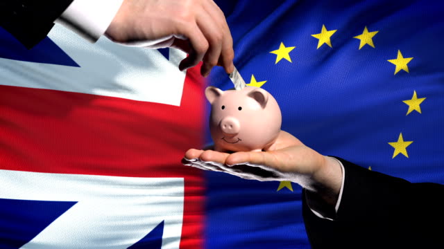Großbritannien-Investitionen-in-die-EU-Hand,-Geld-im-Sparschwein,-Flagge-Hintergrund