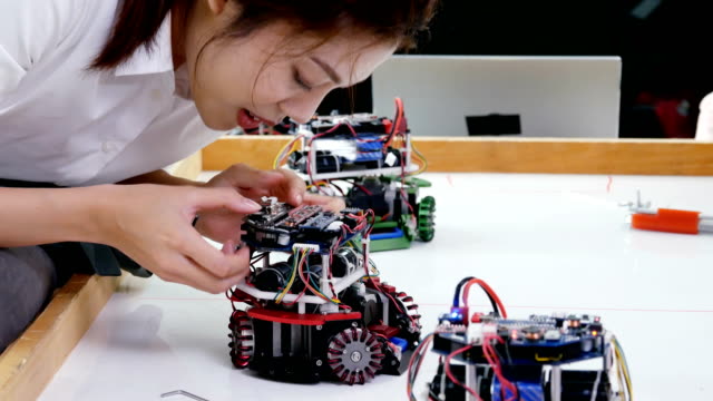 Elektronik-Ingenieure-arbeiten-und-Tests-Mini-Roboter-im-Labor.