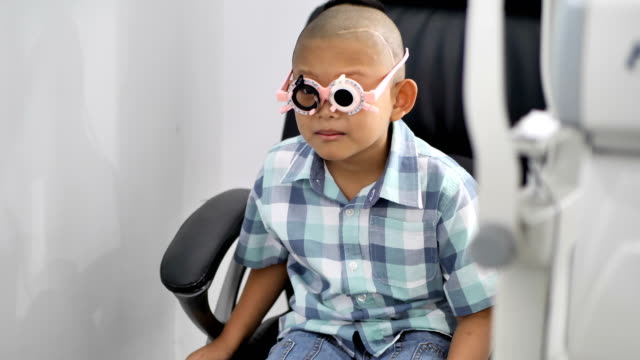 verificación-de-la-vista.-Chicos-asiaticos-que-tienen-discapacidades-de-la-visión.-Ojo-izquierdo-no-es-visible-de-cirugía-cerebral.-Tratamiento-médico-y-rehabilitación