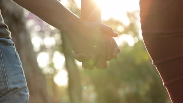Close-up-of-hands-held-together-with-sunlight-flare-shining-through