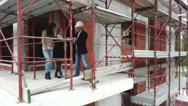 Female-Gay-Couple-Buying-New-Home-In-Construction-Site