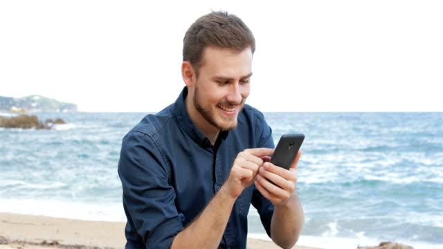 Man-browsing-phone-content-on-the-beach