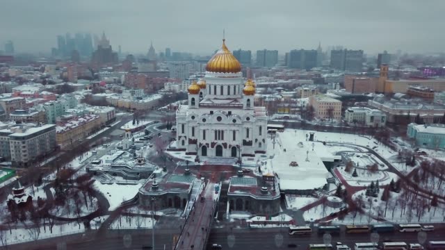 Aerial-shot-around-Russian-Orthodox-Temple-of-Christ-the-Saviour-in-Moscow-in-winter.-There-are-sights,-historical-buildings,-Moscow-city-and-Stalins-skyscrapers-around-the-cathedral.