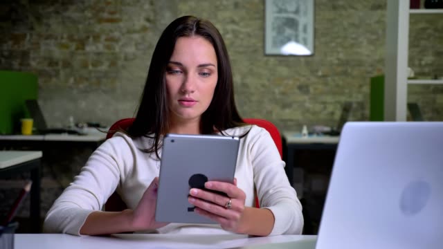 Businesswoman-trabaja-atentamente-con-la-tableta-en-la-oficina
