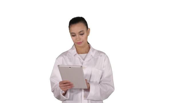 Médico-usando-la-tableta-mientras-camina-sobre-fondo-blanco