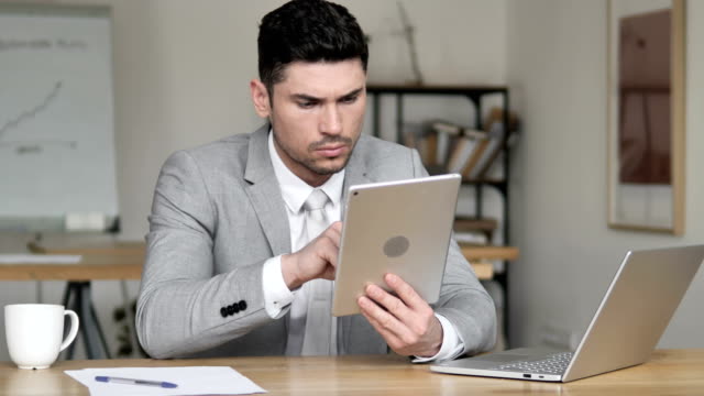 Businessman-Using-Tablet-in-Office