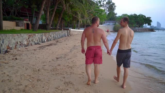 Das-glückliche-schwule-Paar-ruht-an-einem-wunderschönen-tropischen-Strand.-LGBT-Konzept