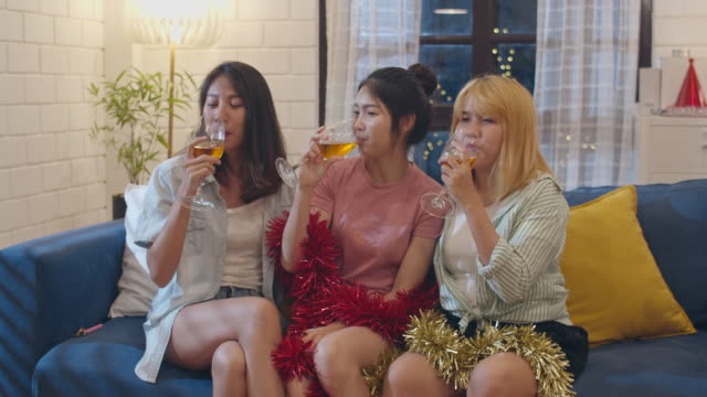 Gruppe-von-asiatischen-Frauen-Party-zu-Hause,-weibliche-Trinken-Cocktail-sprechen-mit-lustigen-zusammen-auf-dem-Sofa-im-Wohnzimmer-in-der-Nacht.-Teenager-junge-Freundin-spielen-Spiel,-Freundschaft,-feiern-Urlaub-Konzept.
