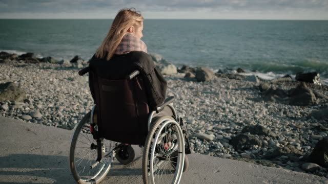Behinderte-Frau-im-Rollstuhl-ist-allein-mit-Meer