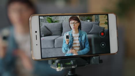 Blogger-recording-video-about-digital-watch-using-smartphone-camera-at-home