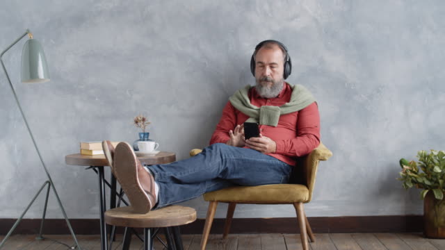 Senior-Man-Enjoying-Music-through-Headphones-at-Home