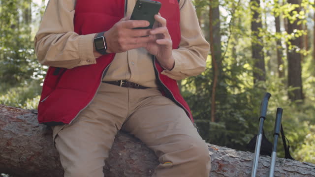 Retired-Hiker-Using-Cellphone-in-Forest