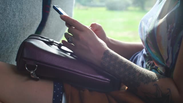 Smartphone-in-den-Händen-eines-Mädchens,-das-mit-einem-Bus-mit-öffentlichen-Verkehrsmitteln-fährt