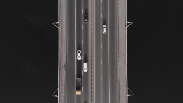 Bridge-highway-dark-water-cars-traffic-aerial-top-view-hover-shot