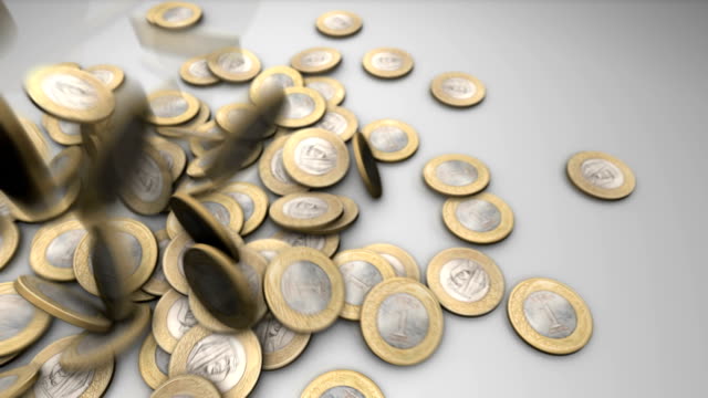 Monedas-Riyal-saudíes-cayendo-sobre-una-superficie-gris