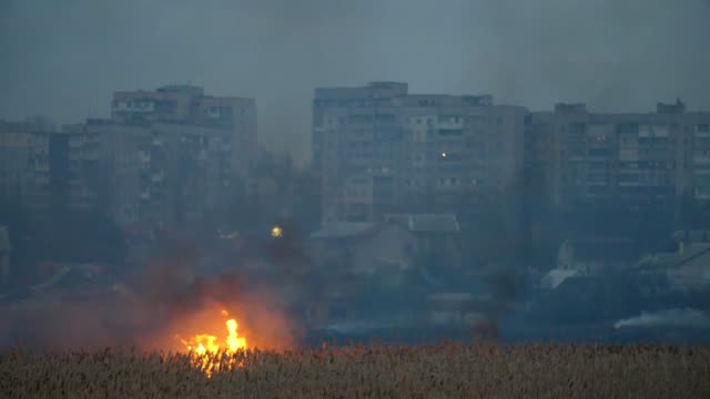 Startling-view-of-multistoried-apartment-blocks-on-the-Dnipro-riverbank-and-the-storming-fire-across-the-river-in-sedge-wetland-in-spring