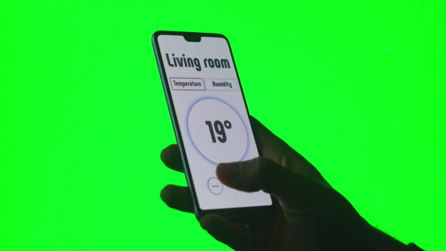 The-hand-controls-the-systems-of-a-modern-technological-home-using-mobile-phone-apps-on-a-green-background-Chromakey-for-keying