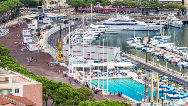 Seaside-swimming-pool-in-Monaco-timelapse,-with-people-and-buildings-in-the-background