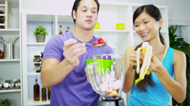 Asian-Chinese-couple-preparing-healthy-homemade-fruit-smoothie