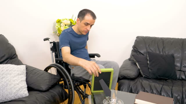 Melancholische-traurige-junge-Behinderte-Mann-mit-Blick-auf-ein-Foto