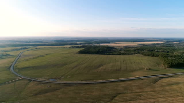 Flight-above-countryside-green-fields,-forest,-and-village-early-spring,-aerial-panoramic-view.