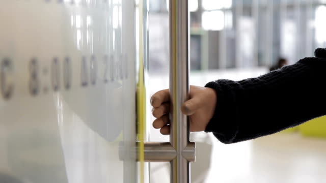 Man-is-opening-glass-door-by-bionic-hand-and-going-into