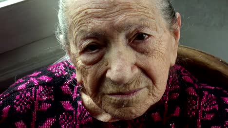 elderly-relaxed-and-serene-woman-at-home:-closeup-portrait-looking-direct-in-the
