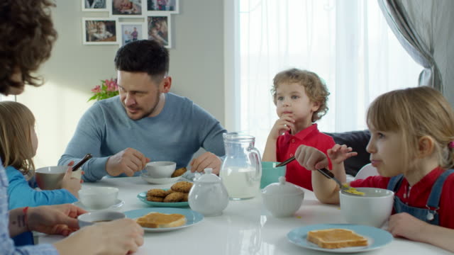 Familia-con-tres-niños-desayunando