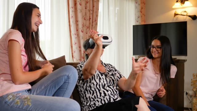 Ältere-Frau,-die-Spaß-mit-virtual-Reality-Brille-und-ihre-Enkelinnen