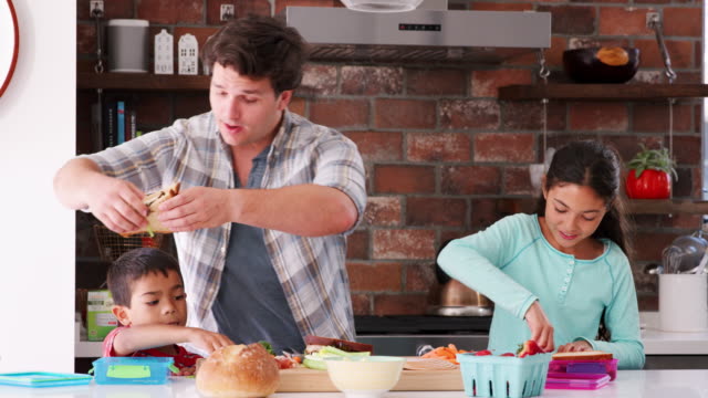 Children-Helping-Father-To-Make-Sandwiches-For-Packed-Lunch-In-Kitchen