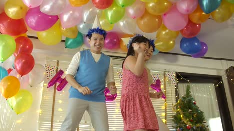 Happy-young-Asian-family-dancing-together-in-party-event-at-home.-Happy-family-celebrating-New-Year's-Eve.