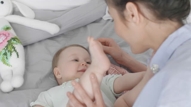 Young-woman-and-baby-relaxing-on-bed